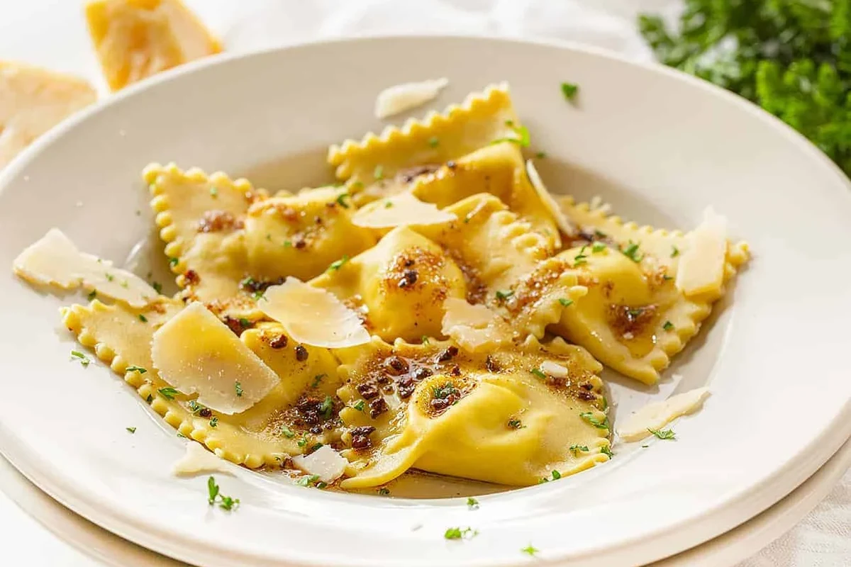 Bowl of cooked ravioli with sauce on a kitchen table