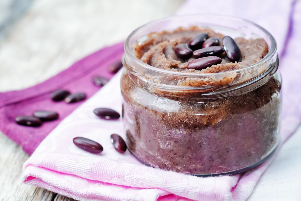 Bowl of smooth red bean paste with buns and dessert ingredients on a kitchen counter