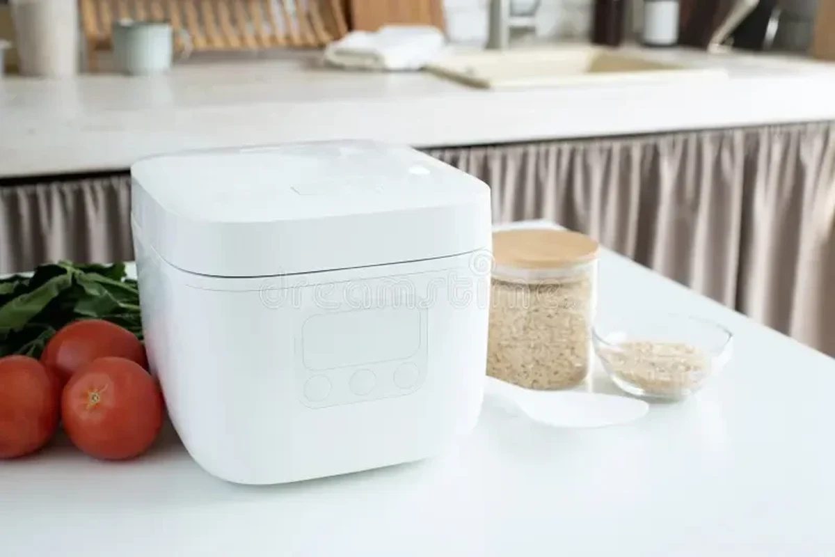 Rice cooker with cooked pasta in the inner pot on a clean kitchen counter