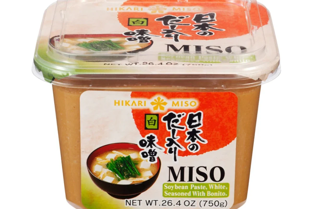 Fermented soybean paste and miso jars with spoons on a kitchen counter