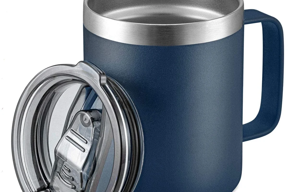 Stainless steel coffee mug with lid beside a coffee maker on a kitchen counter