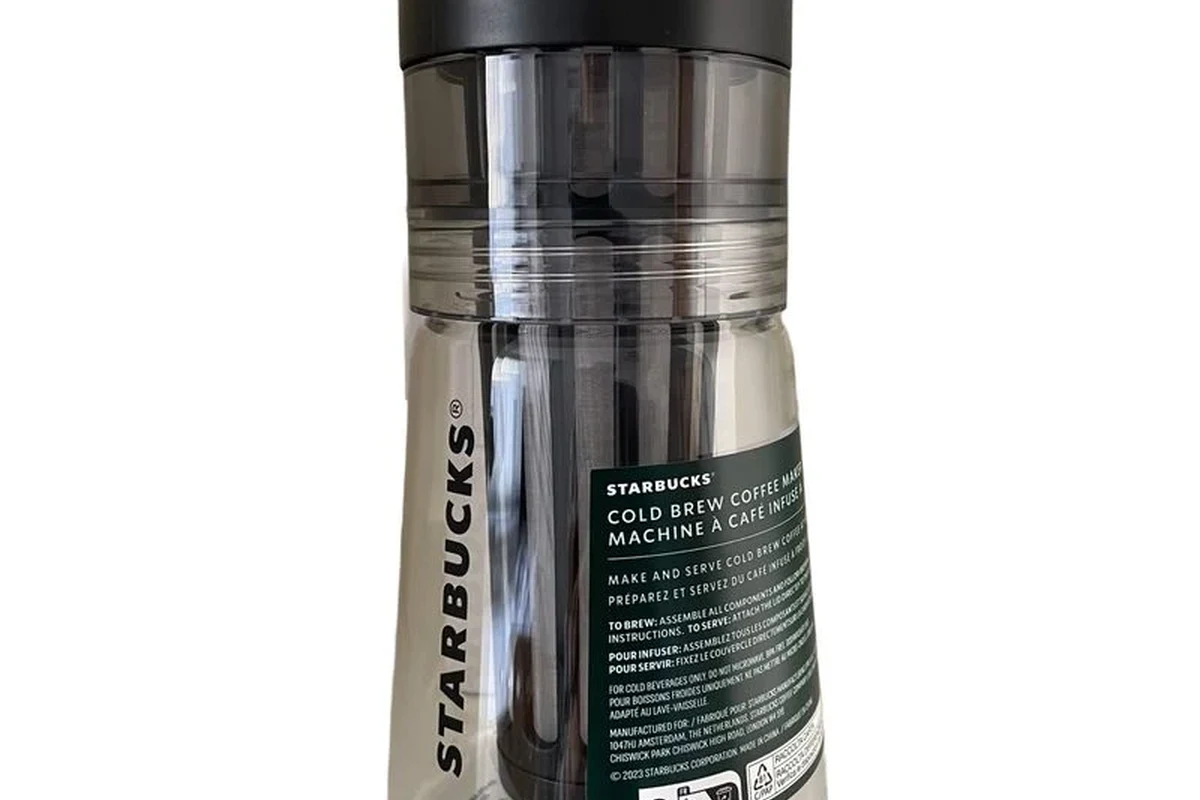 Starbucks cold brew coffee maker with ground coffee, water, and a finished glass of iced cold brew