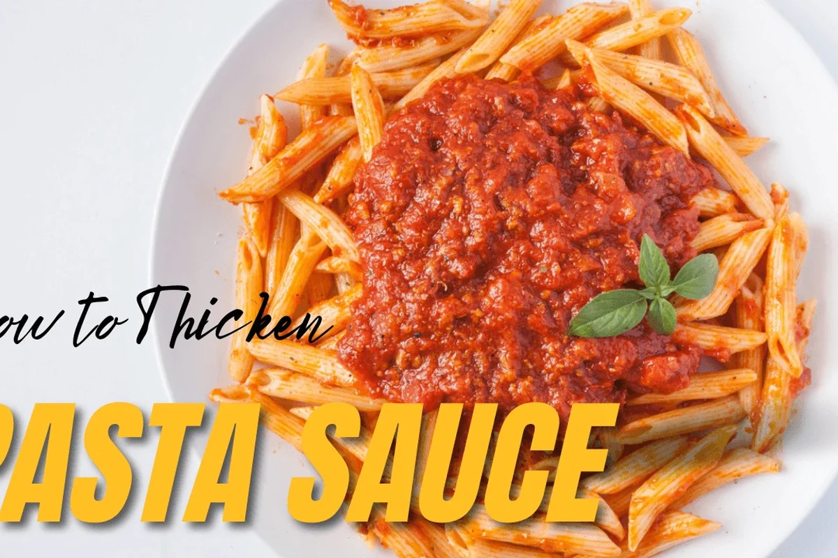 A pot of pasta sauce simmering on a stove with a spoon and ingredients nearby