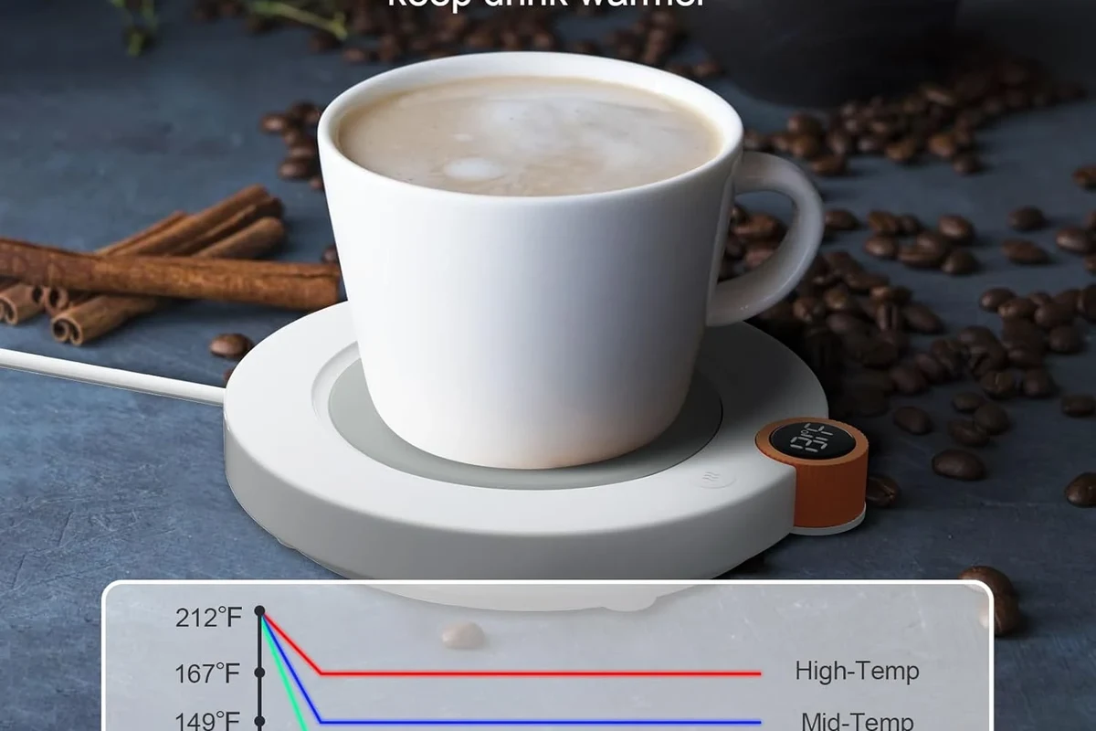 Coffee mug warmer on a kitchen counter beside a ceramic mug of hot coffee
