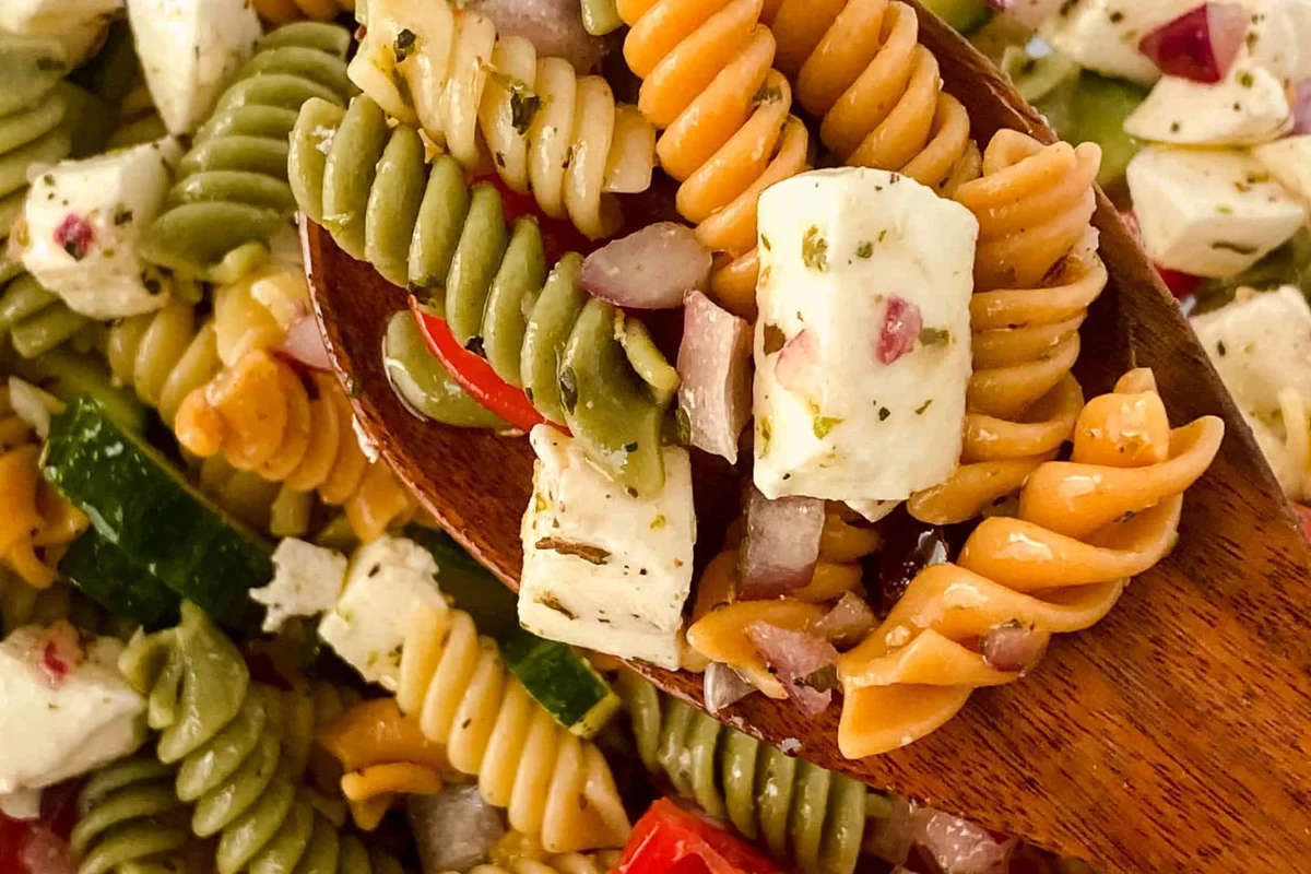 Tri color pasta and regular pasta served side by side in a home kitchen