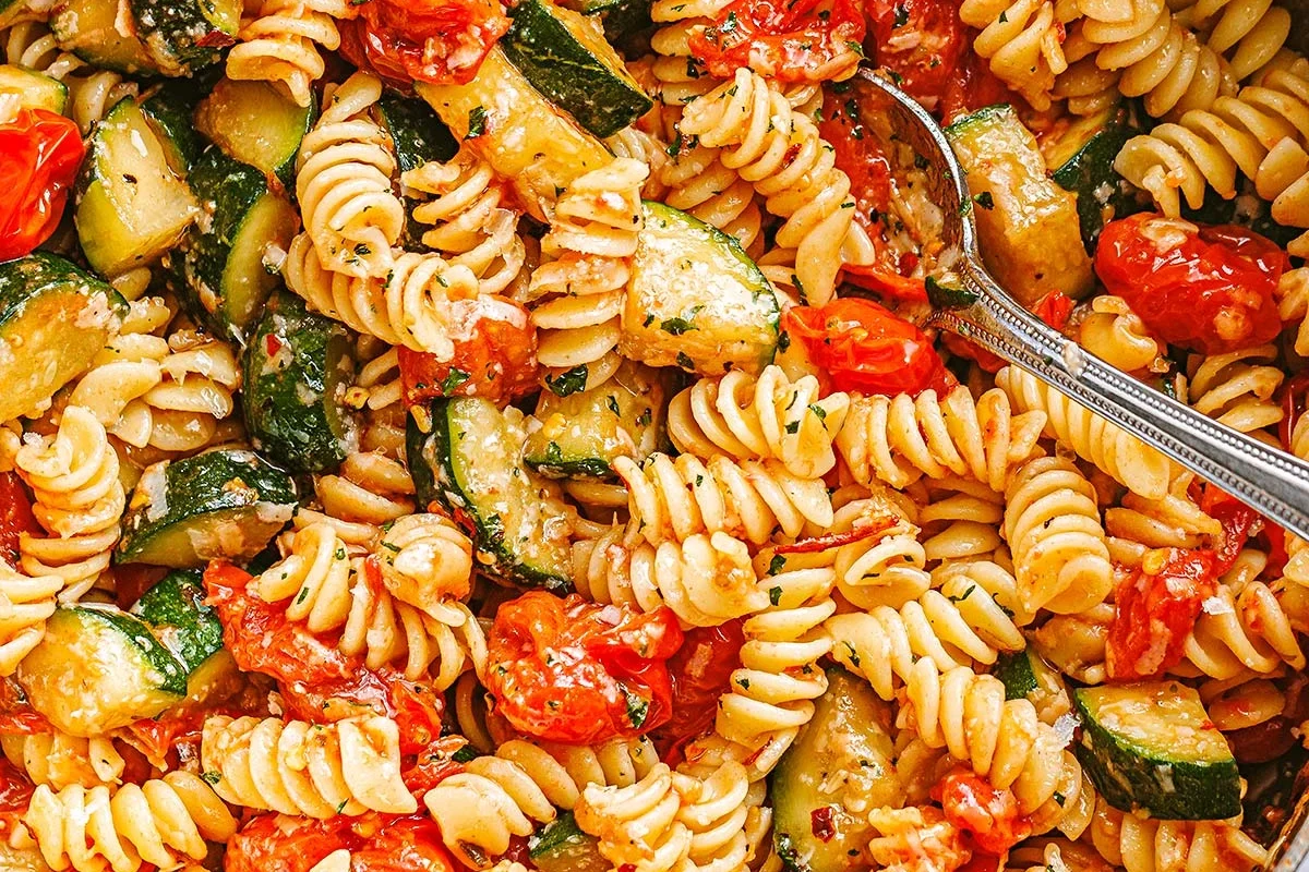 Bowls of whole wheat, legume, and gluten-free pasta with vegetables on a kitchen table