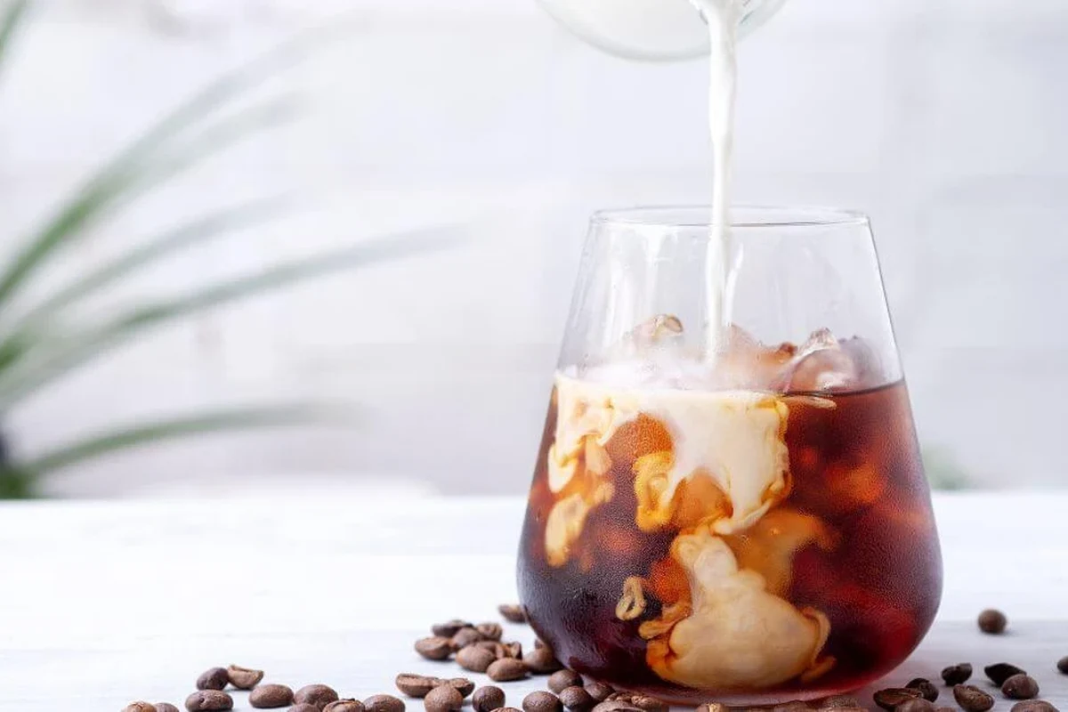 Glass of plain cold brew coffee on a kitchen counter beside fasting-friendly coffee tools