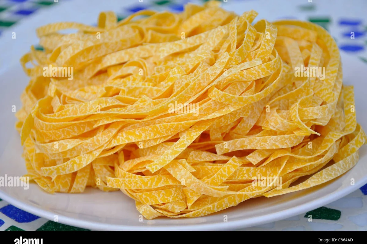 Fresh egg pasta drying on a rack in a clean home kitchen